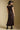 Back view of a woman wearing the Saltwater Luxe Tayler Midi Dress on a neutral background