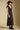 Side angle view of a woman wearing the Saltwater Luxe Tayler Midi Dress on a neutral background with shoes