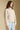 Side angle view of a woman wearing the Saltwater Luxe Tovie Jacket on a neutral background with bluejeans