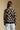 Back view of a woman wearing the floral Saltwater Luxe Vincent Sweater on a neutral background