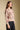 Side angle view of a woman wearing the floral Saltwater Luxe Vincent Sweater on a neutral background with hand in pocket