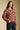 Side angle view of a woman wearing the floral Saltwater Luxe Vincent Sweater on a neutral background with hand in pocket