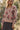 Front view of a woman wearing the floral Saltwater Luxe Vincent Sweater in a garden over the Nolla Skirt