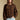 Front view of a woman wearing the Saltwater Luxe  Xenia Chocolate Sweater on a neutral background with hand in pocket