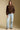 A full body front view of a woman wearing the Saltwater Luxe  Xenia Chocolate Sweater on a neutral background