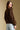 Back view of a woman wearing the Saltwater Luxe  Xenia Chocolate Sweater on a neutral background with jeans