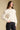 Front view of a woman wearing the Saltwater Luxe  Jeri Sweater on a neutral background with hand on hip