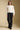A full body front view of a woman wearing the Saltwater Luxe  Jeri Sweater on a neutral background