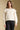 Front view of a woman wearing the Saltwater Luxe  Jeri Sweater on a neutral background with black pants