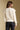 Back view of a woman wearing the Saltwater Luxe  Jeri Sweater on a neutral background with pants