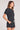 Side angle view of a woman wearing the Saltwater Luxe Short Sleeve Black Pullover on a neutral background