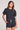 Front view of a woman wearing the Saltwater Luxe Short Sleeve Black Pullover on a neutral background
