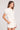 Side angle view of a woman wearing the Saltwater Luxe Short Sleeve Ecru Pullover on a neutral background