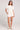 A full body front view of a woman wearing the Saltwater Luxe Short Sleeve Ecru Pullover on a neutral background