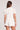 Back view of a woman wearing the Saltwater Luxe Short Sleeve Ecru Pullover on a neutral background