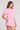 Side angle view of a woman wearing the Saltwater Luxe Short Sleeve Petunia Pullover on a neutral background