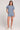 A full body front view of a woman wearing the Saltwater Luxe Short Sleeve Worn Blue Pullover on a neutral background