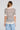 Back view of a woman wearing the Saltwater Luxe Siera Natural Top on a neutral background
