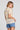 Back view of a woman wearing the Saltwater Luxe Siera Top in Sunglow on a neutral background