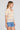 Side angle view of a woman wearing the Saltwater Luxe Siera Top in Sunglow on a neutral background