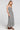 Side angle view of a woman wearing the Saltwater Luxe Stein Midi Dress on a neutral background