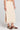 Side angle view of a woman wearing the Saltwater Luxe Suzi Midi Skirt in Natural on a neutral background