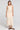 Full body front view of a woman wearing the Saltwater Luxe Suzi Midi Skirt in Natural on a neutral background