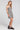 Side angle view of a woman wearing the Saltwater Luxe Sydney Mini Dress on a neutral background