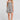 Front view of a woman wearing the Saltwater Luxe Sydney Mini Dress on a neutral background with one hand in her pocket