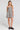 Front view of a woman wearing the Saltwater Luxe Sydney Mini Dress on a neutral background with one hand in her pocket