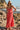 Front view of a woman wearing the Saltwater Luxe Tarynnia Cranberry Maxi Dress on the beach