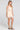 Side angle view of a woman wearing the Saltwater Luxe Waverlee Mini Dress in Natural on a neutral background