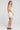 Back view of a woman wearing the Saltwater Luxe Waverlee Mini Dress in Natural on a neutral background