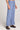 Side angle view of a woman wearing the Saltwater Luxe Woven Worn Blue Pull On Pant on a neutral background
