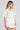 Side angle view of a woman wearing the Saltwater Luxe Zerra Top on a neutral background
