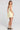 Back view of a woman wearing the Saltwater Luxe  Zurina Mini Dress in Sunglow on a neutral background