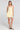 Front view of a woman wearing the Saltwater Luxe  Zurina Mini Dress in Sunglow on a neutral background