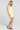 Side angle view of a woman wearing the Saltwater Luxe  Zurina Mini Dress in Sunglow on a neutral background