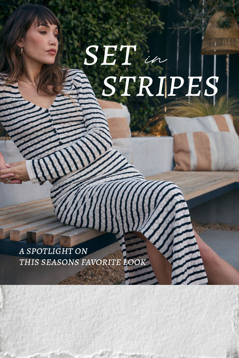 Woman wearing a black and white striped outfit sitting on a bench with text overlay 'Set in Stripes'.